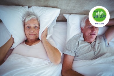 femme senior insomnie à cause des ronflements de son conjoint se plaque l'oreiller sur les oreilles