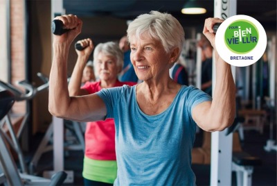 femme senior soulève des poids avec ses bras dans un gymnase