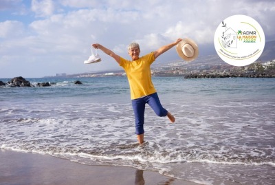 femme senior sautant dans les vagues