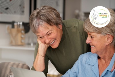 deux femmes seniors riant devant un ordinateur