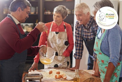 groupe de seniors et animatrice pendant un cours collectif de cuisine