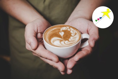 gros plan mains tenant une tasse de boisson chaude dont la mousse forme un cœur