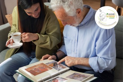 grand père regardant avec sa petite fille des photos dans un vieil album photos