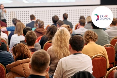 personnes de dos assistant à une conférence