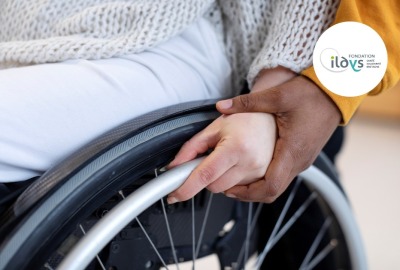 gros plan mains couple posées l'une au-dessus de l'autre sur la roue d'un fauteuil roulant