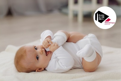 bébé allongé sur le dos sur un tapis et jouant avec ses pieds