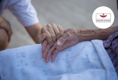 gros plan main d'une jeune femme serrant celle d'une personne âgée