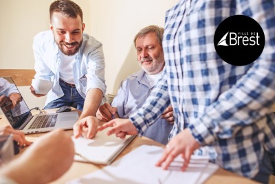 groupe de 3 personnes travaillant sur un projet à leur bureau