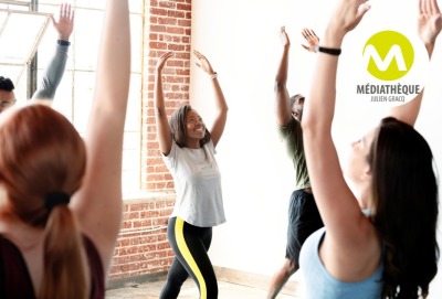 groupe de personnes effectuant des mouvements avec leurs bras pendant un cours de danse collectif