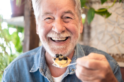 homme senior heureux manger gâteau